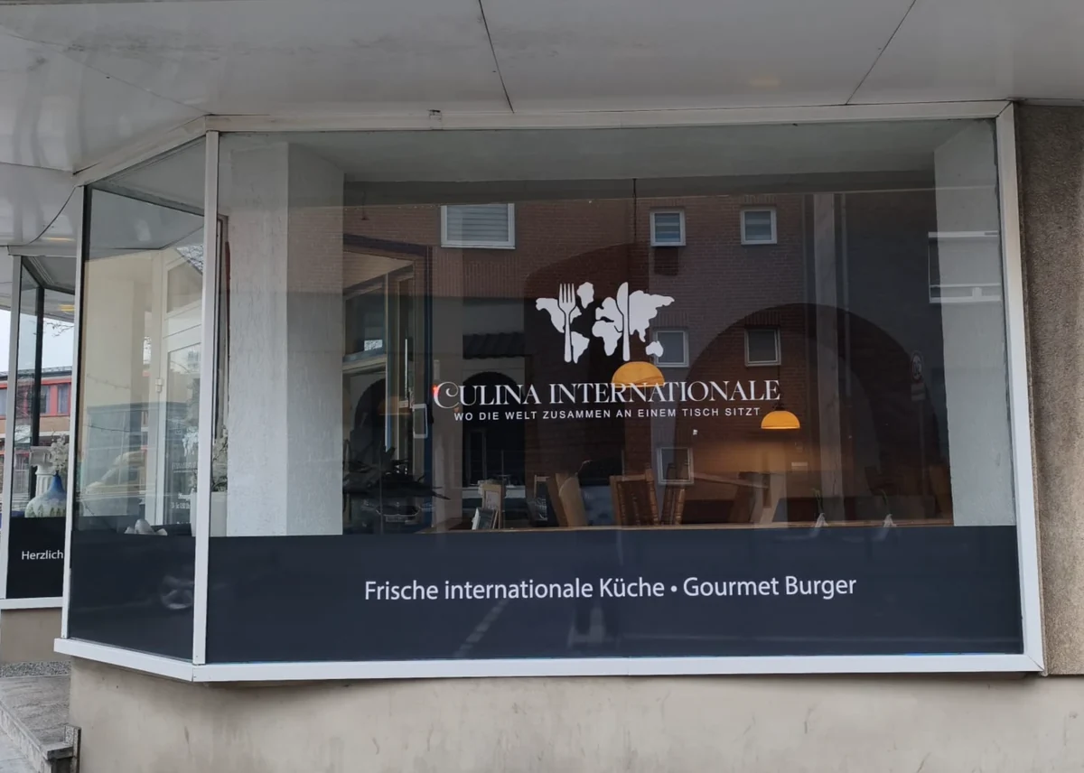 Schaufensterbeschriftung mit weißem Logo und Schriftzug für Culina Internationale